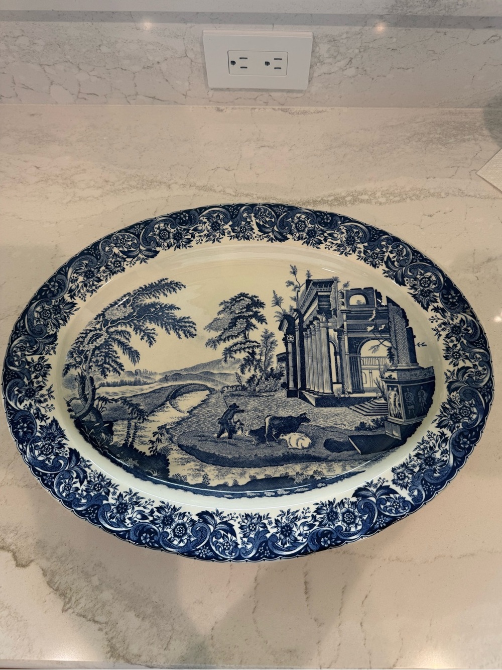 Vintage blue transferware oval platter featuring a cattle and castle scene